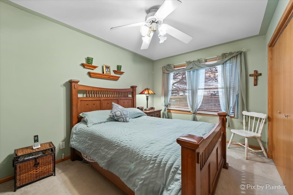 705 Cherry Tree Lane Genoa, IL 60135 - Photo 9 of 31 a bedroom with a bed and a chandelier