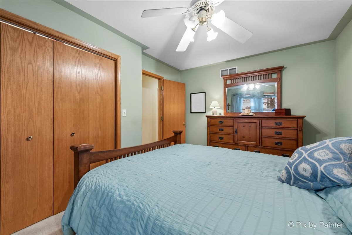 705 Cherry Tree Lane Genoa, IL 60135 - Photo 10 of 31 a bedroom with a bed and a chandelier