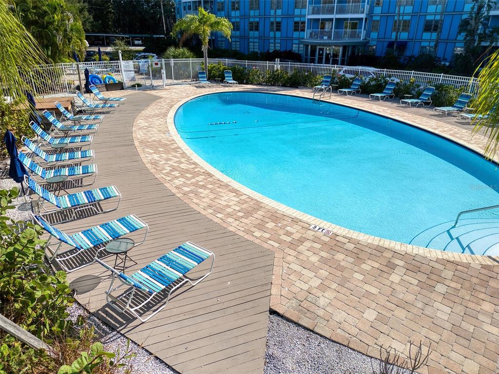 3315 58th Avenue South, Unit 112 St. Petersburg, FL 33712 - Photo 31 of 38 a swimming pool with outdoor seating and yard