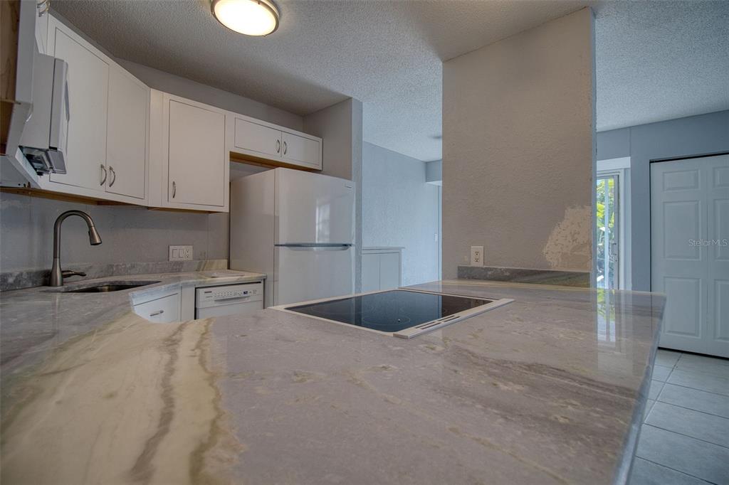 3315 58th Avenue South, Unit 112 St. Petersburg, FL 33712 - Photo 8 of 38 a kitchen with stainless steel appliances a sink and a refrigerator