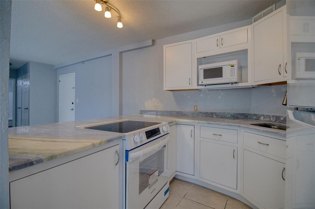 3315 58th Avenue South, Unit 112 St. Petersburg, FL 33712 - Photo 10 of 38 a kitchen with granite countertop white cabinets white stainless steel appliances and sink