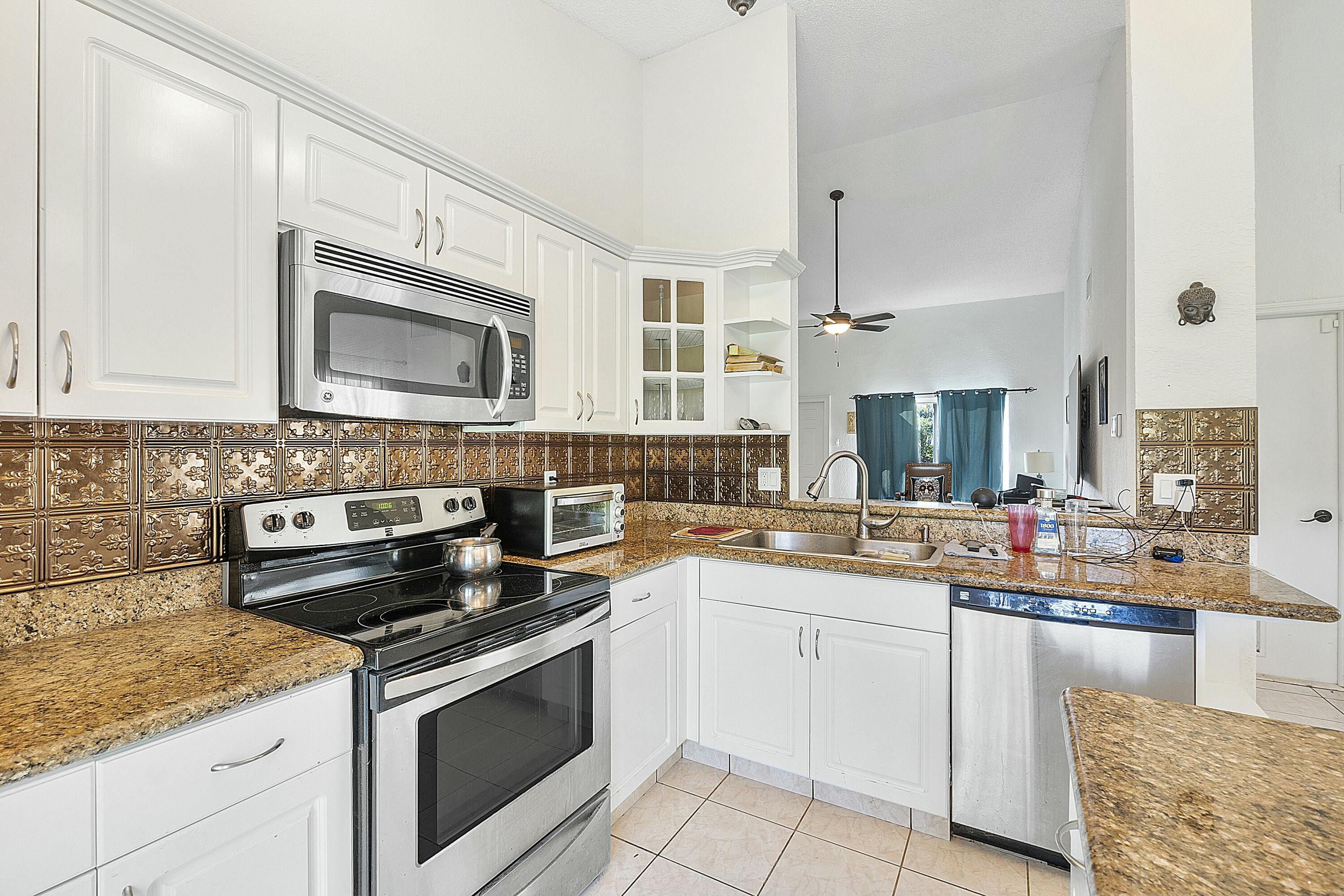 8143 Cedar Hollow Lane Boca Raton, FL 33433 - Photo 15 of 29 a kitchen with a sink stove and microwave