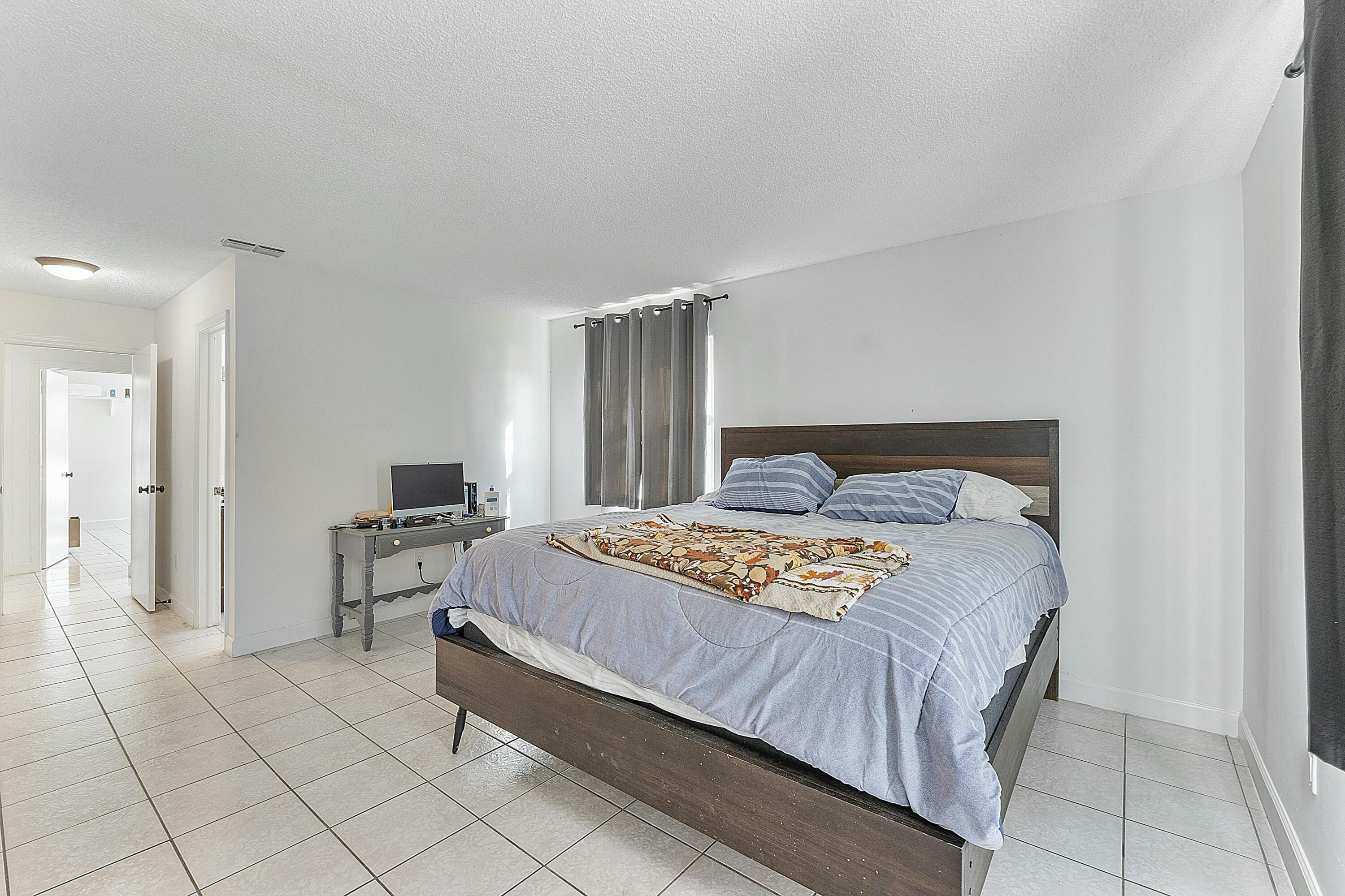 8143 Cedar Hollow Lane Boca Raton, FL 33433 - Photo 18 of 29 a bedroom with a bed and a television