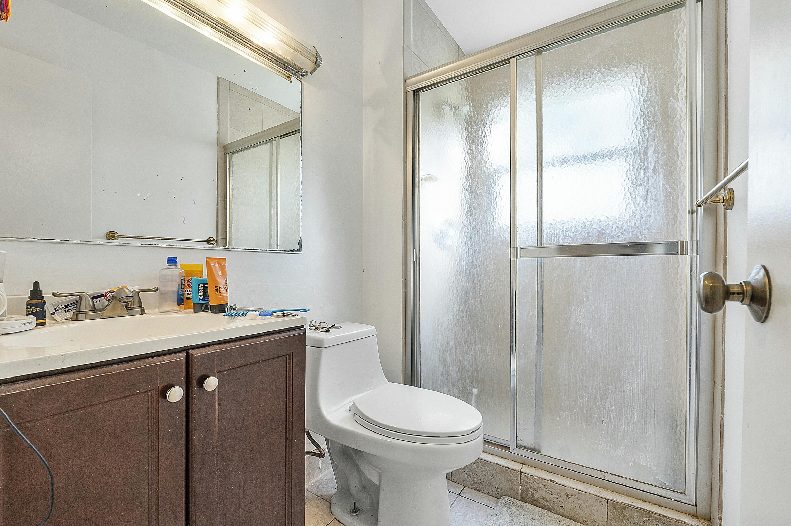 8143 Cedar Hollow Lane Boca Raton, FL 33433 - Photo 19 of 29 a bathroom with a sink a toilet and shower