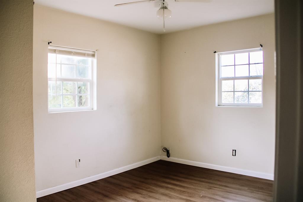 311 Spann Street Bangs, TX 76823 - Photo 16 of 17 an empty room with wooden floor and windows