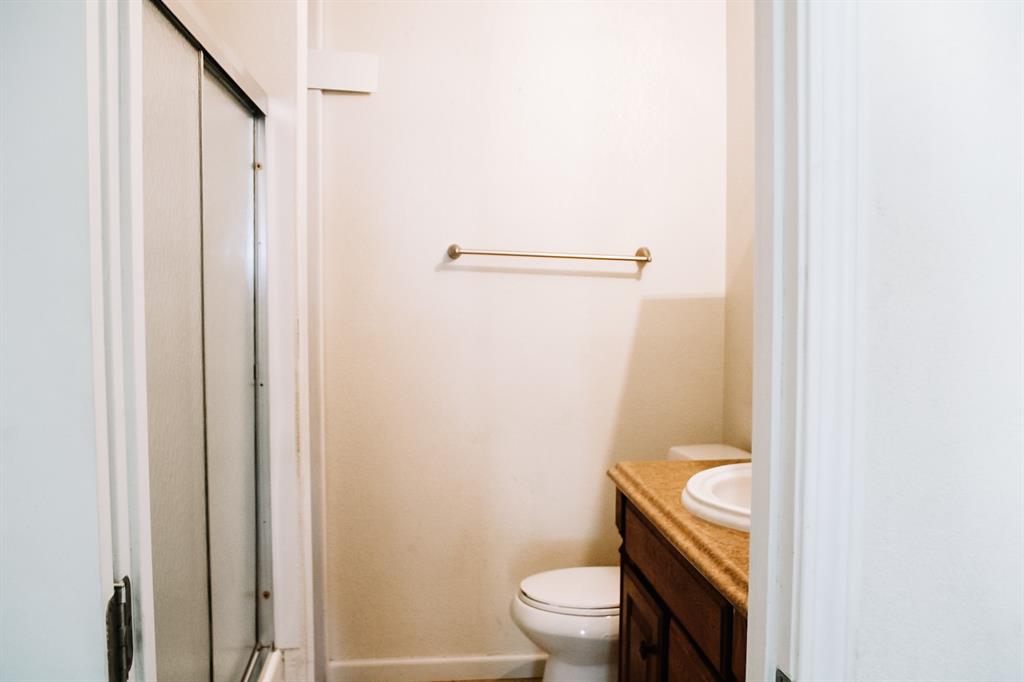 311 Spann Street Bangs, TX 76823 - Photo 17 of 17 a white toilet sitting next to a shower curtain