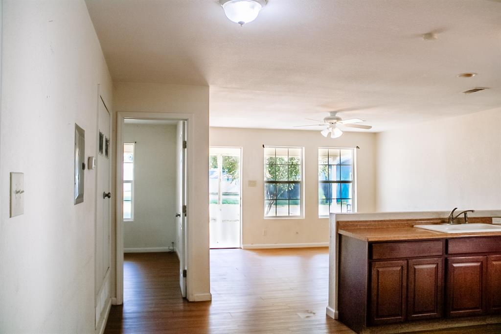 311 Spann Street Bangs, TX 76823 - Photo 6 of 17 a view of a hallway with wooden floor and a kitchen
