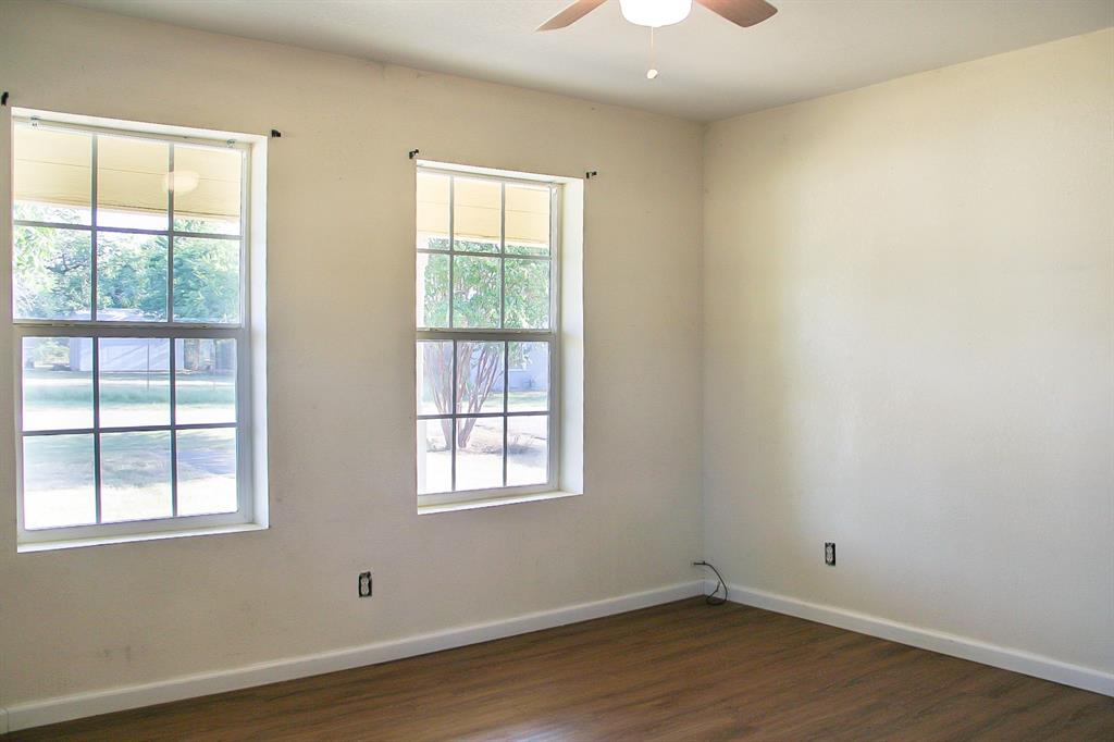 311 Spann Street Bangs, TX 76823 - Photo 10 of 17 an empty room with wooden floor and windows