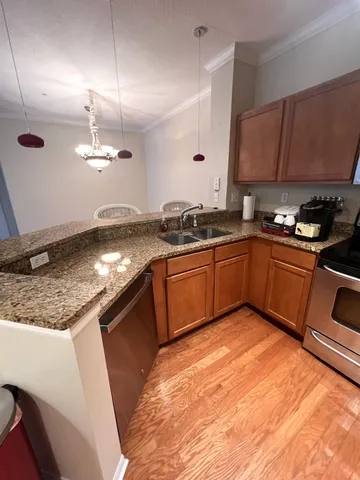 a kitchen with granite countertop stainless steel appliances and wooden cabinets