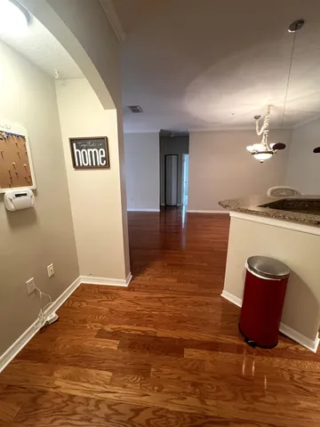 a view of a kitchen with kitchen island a sink wooden floor and glass door