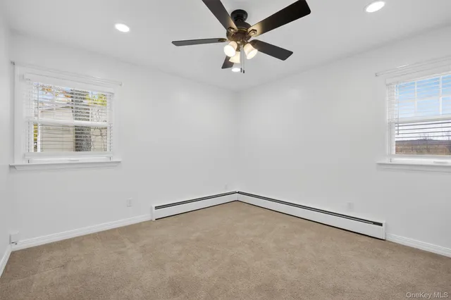 an empty room with a window and ceiling fan