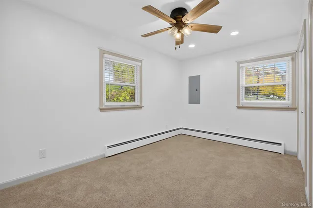 an empty room with windows and fan