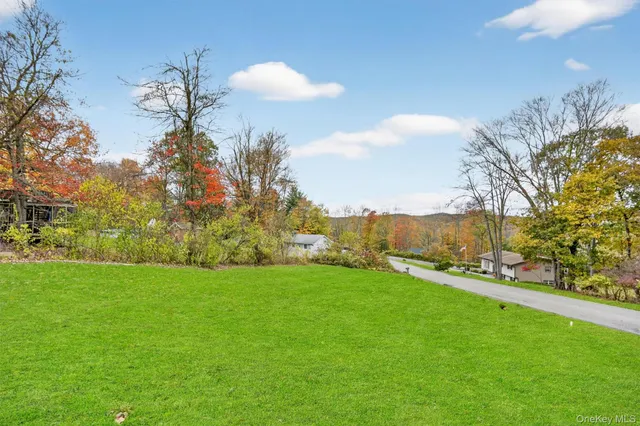 a backyard of a house with lots of green space and lake view