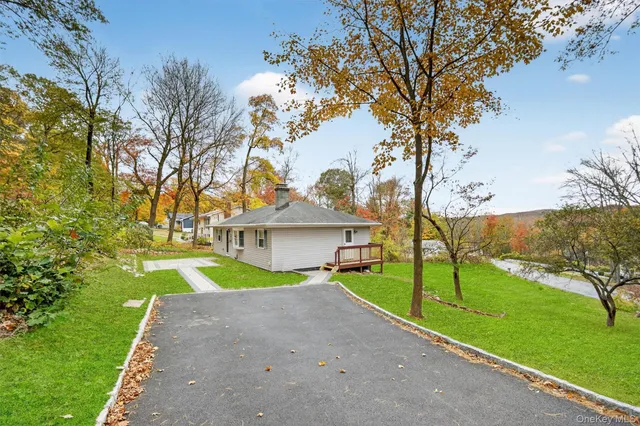 a view of house with a big yard and palm trees