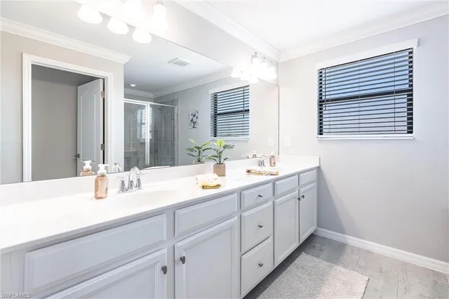 a bedroom that has two beds and a chandelier