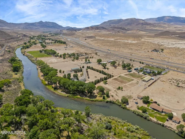 an aerial view of a city with lots of residential buildings ocean and mountain view in back