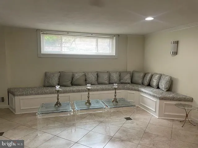 a room with a chair a mirror and white walls