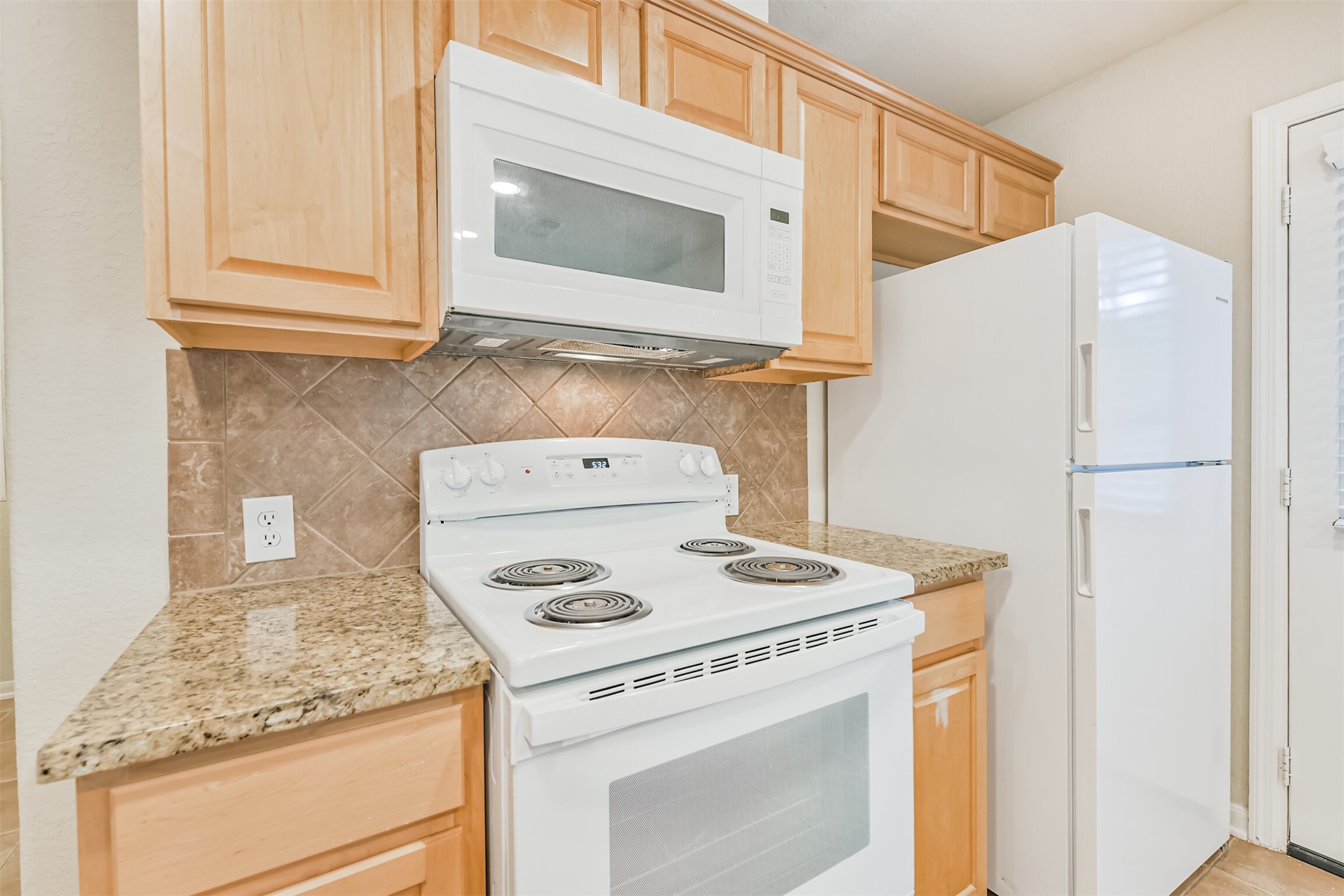 42 Prairie Oak Drive Conroe, TX 77385 - Photo 11 of 33 a kitchen with a stove and a microwave