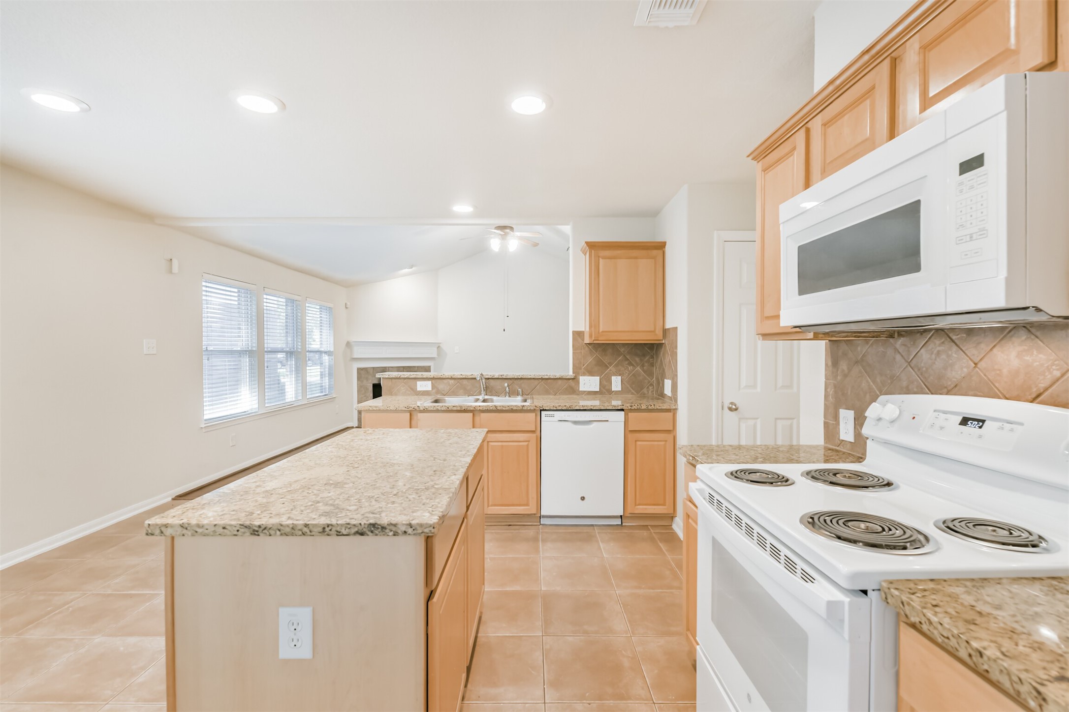 42 Prairie Oak Drive Conroe, TX 77385 - Photo 12 of 33 a kitchen with a stove a sink and a microwave