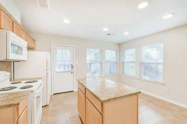 a large kitchen with granite countertop a sink and a stove top oven