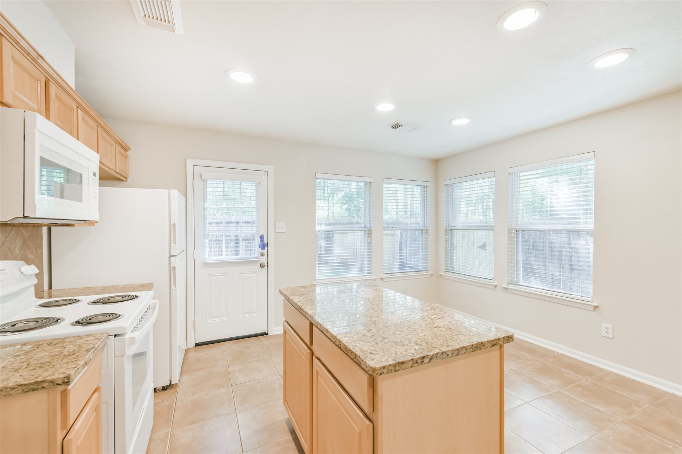42 Prairie Oak Drive Conroe, TX 77385 - Photo 13 of 33 a large kitchen with granite countertop a sink and a stove top oven