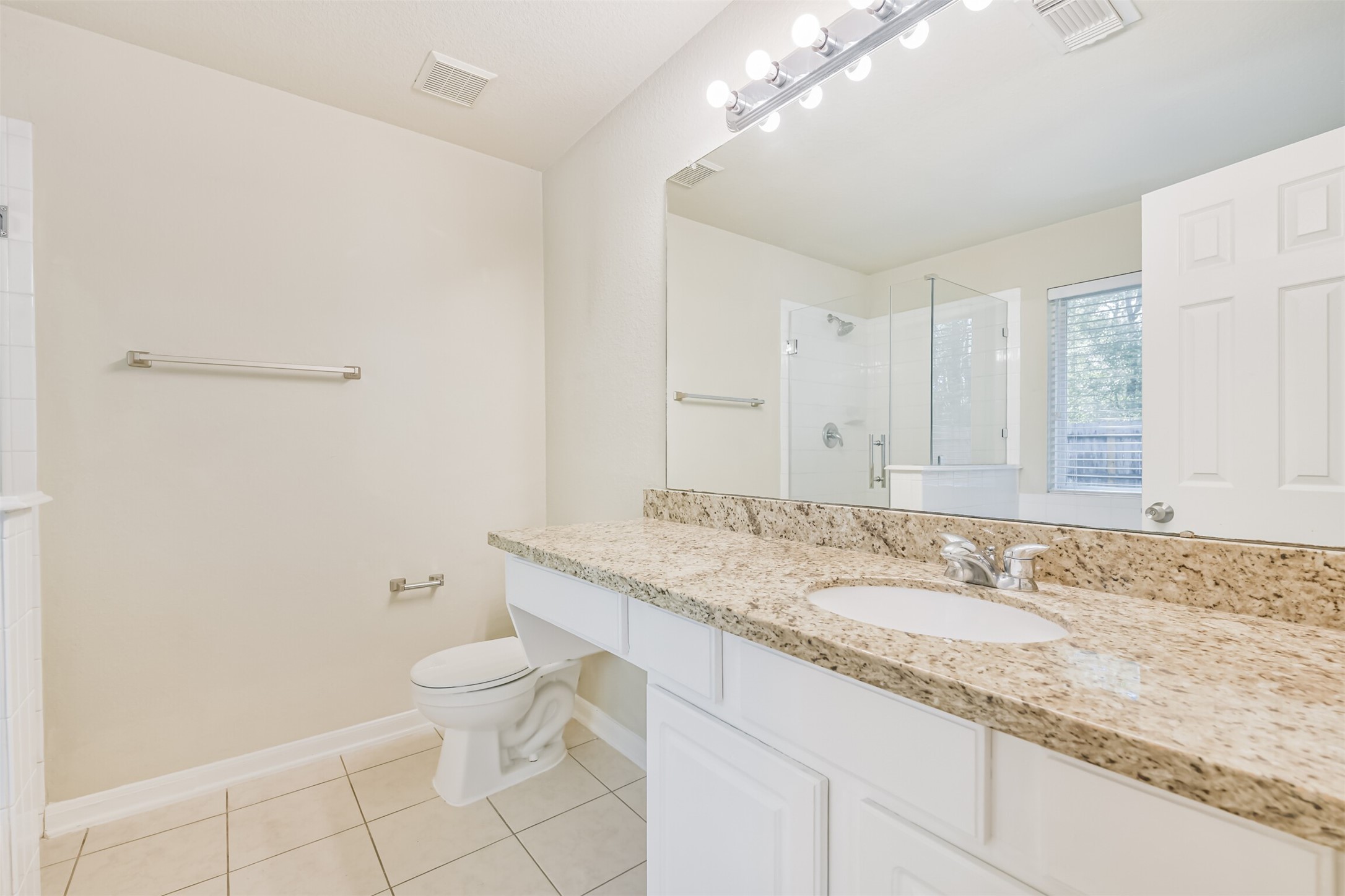 42 Prairie Oak Drive Conroe, TX 77385 - Photo 20 of 33 a bathroom with a granite countertop sink a toilet and a mirror