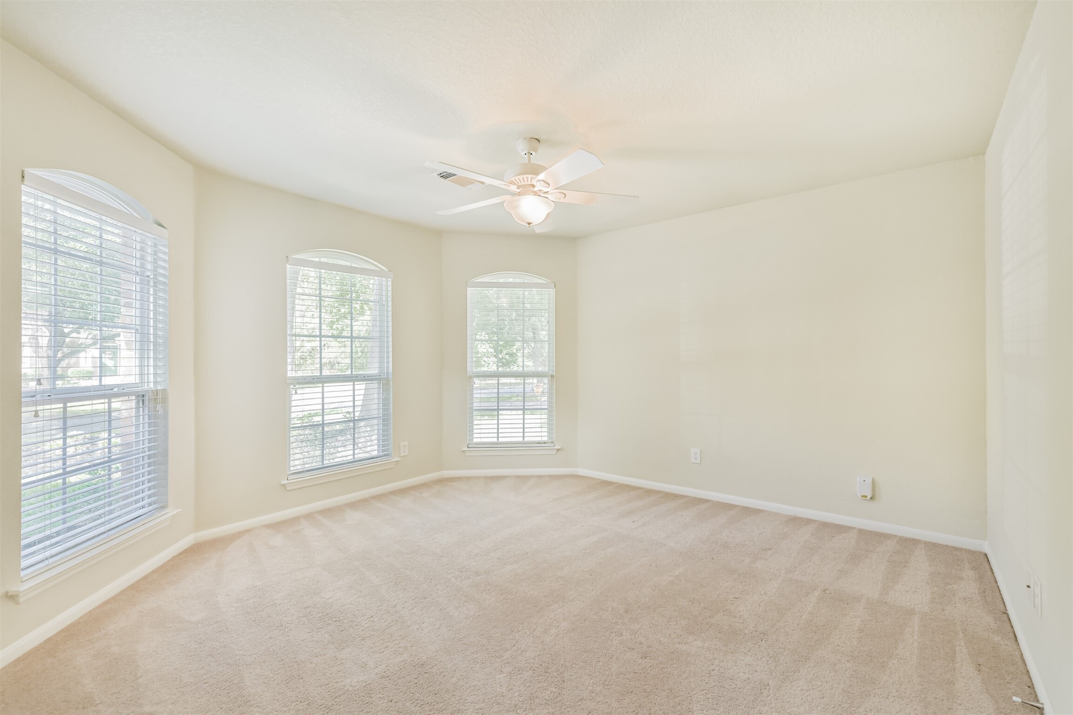 42 Prairie Oak Drive Conroe, TX 77385 - Photo 23 of 33 an empty room with chandelier fan and windows