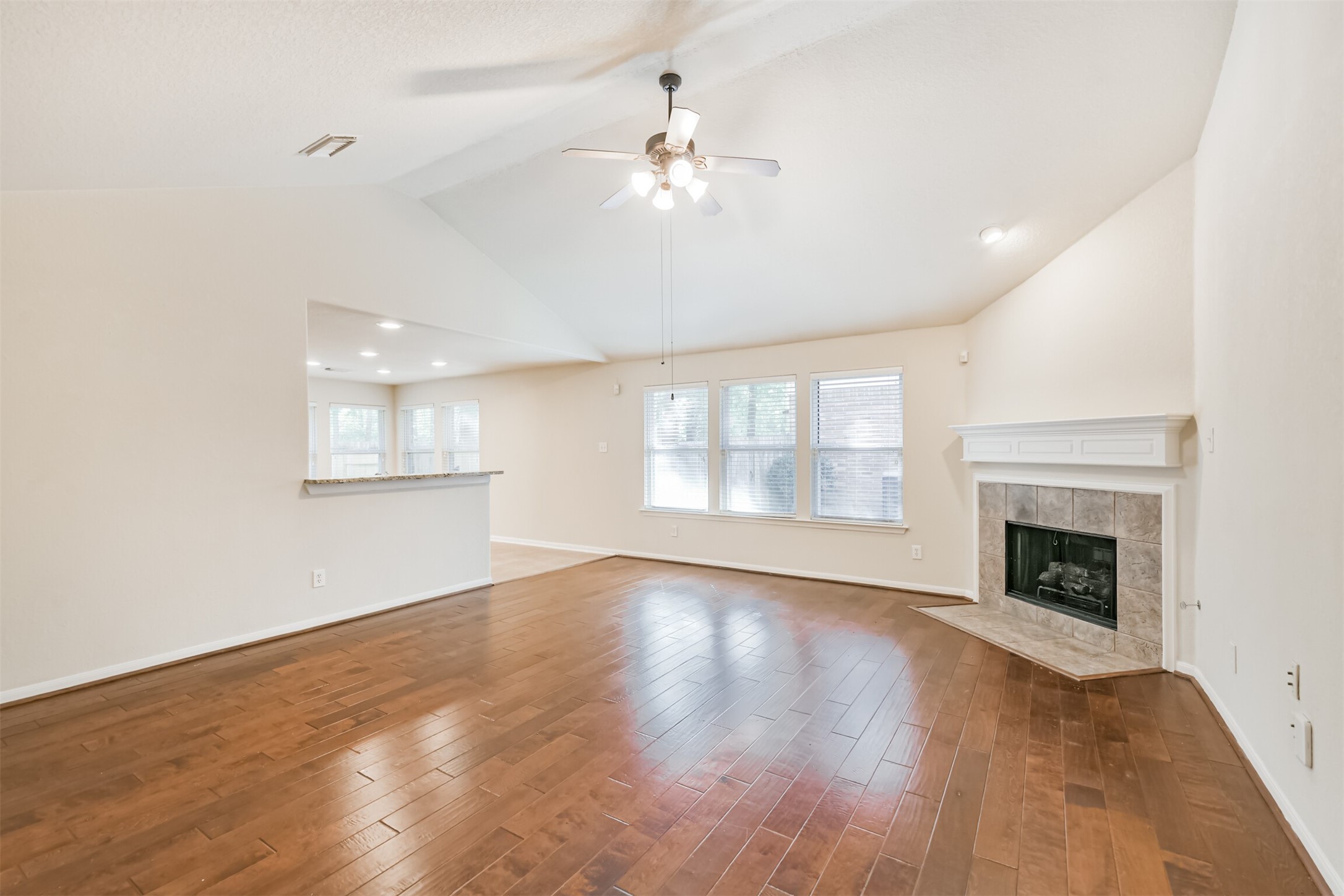 42 Prairie Oak Drive Conroe, TX 77385 - Photo 5 of 33 an empty room with wooden floor fireplace and windows