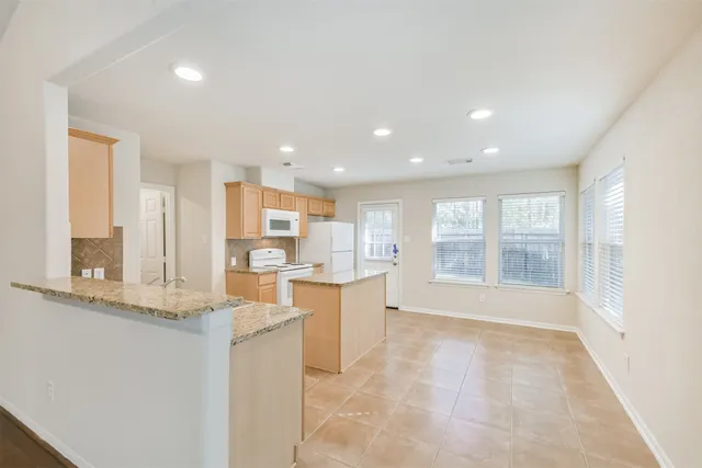 a large white kitchen with a large window