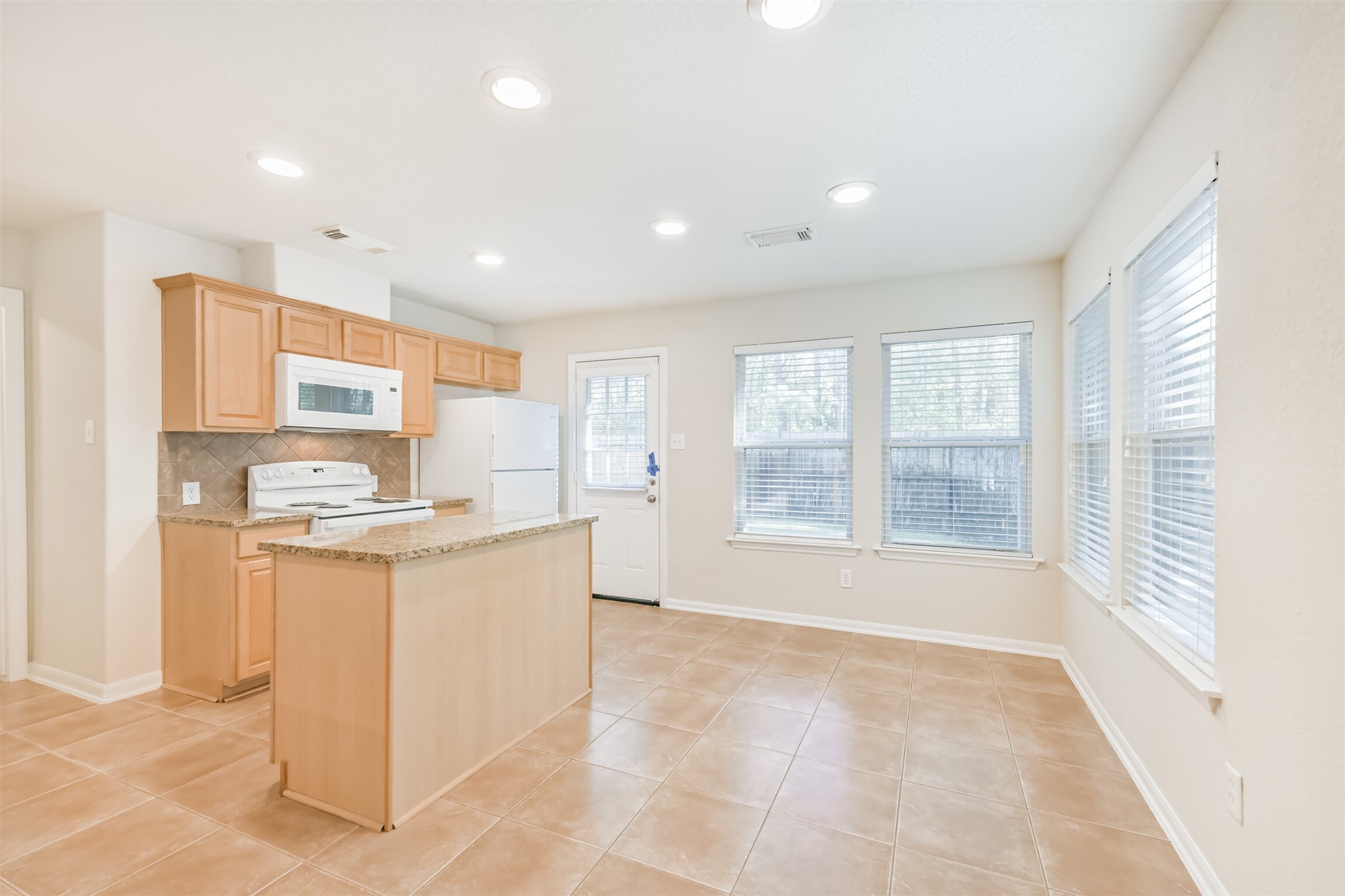 42 Prairie Oak Drive Conroe, TX 77385 - Photo 9 of 33 a kitchen with stainless steel appliances granite countertop a stove and a refrigerator