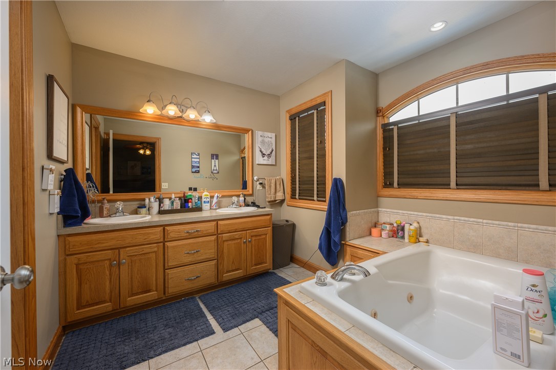 806 Forrest Ridge Drive Dover, OH 44622 - Photo 24 of 36 Full bathroom with double vanity, light tile patterned floors, and a tub with jets
