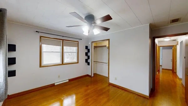 an empty room with wooden floor and closet