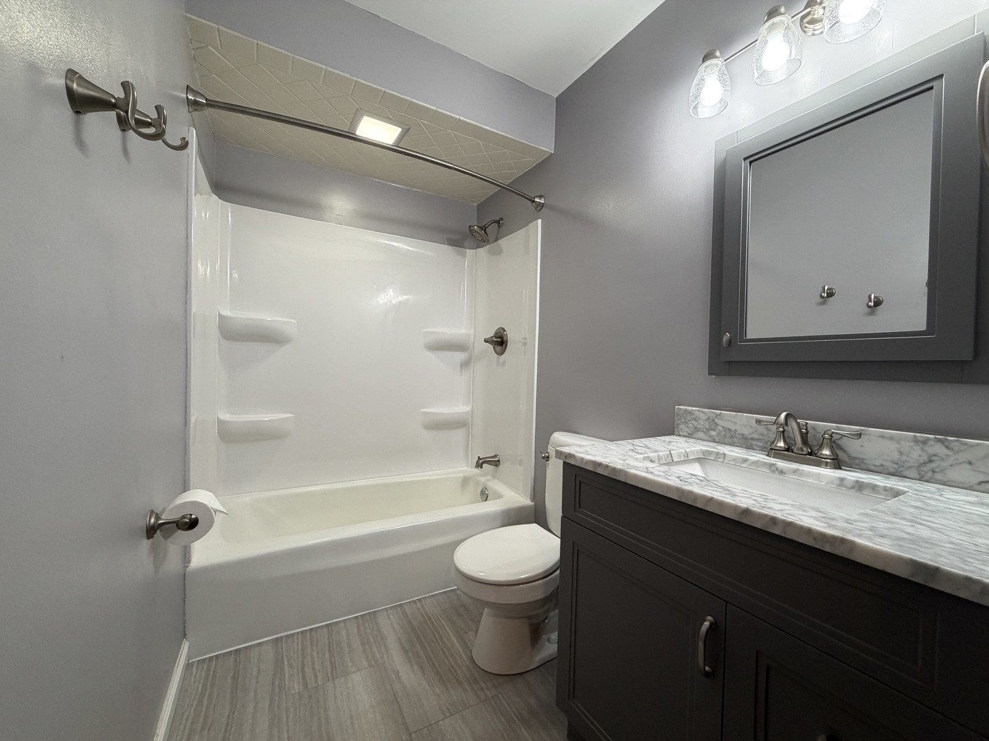 605 Douglas Street Catlin, IL 61817 - Photo 31 of 41 a bathroom with a granite countertop sink toilet a large mirror a shower and bathtub