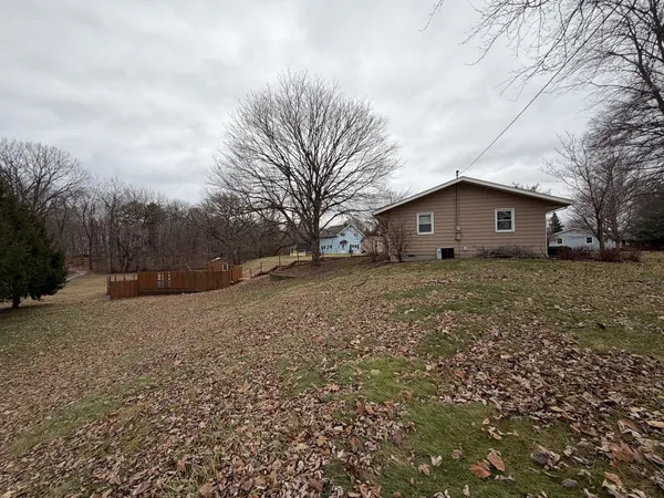 a view of a house with a big yard and large trees