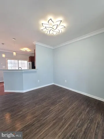 a view of a room with wooden floor and a ceiling fan