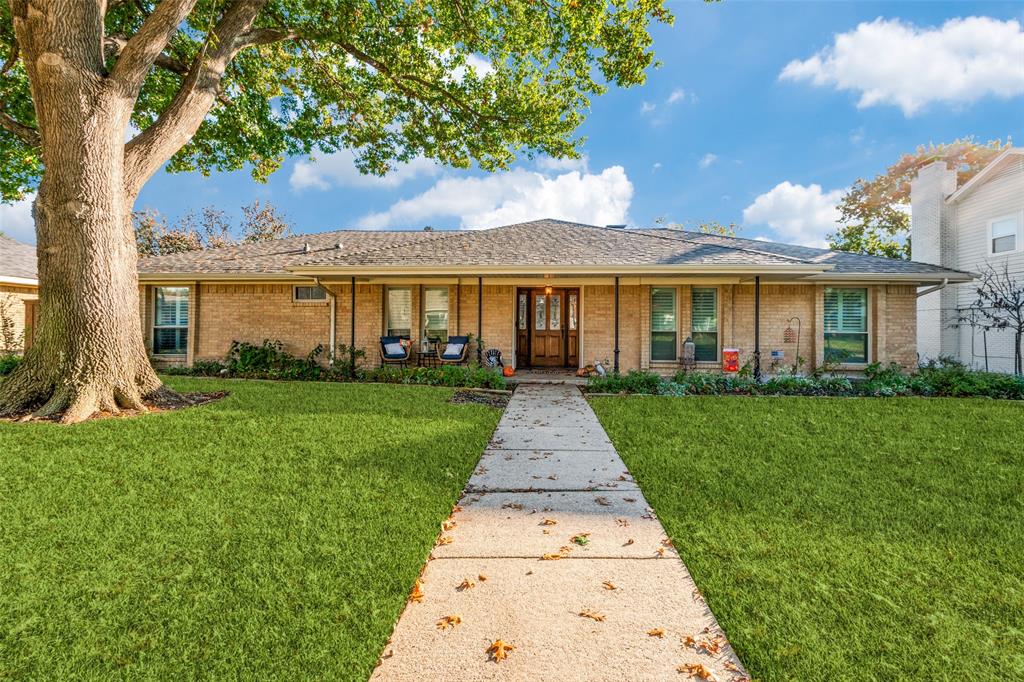 a front view of a house with a yard and potted plants