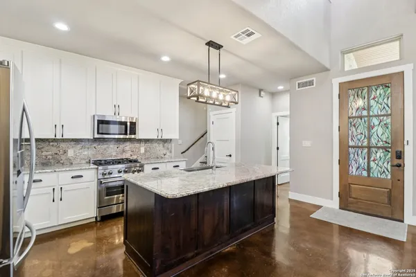 a kitchen with stainless steel appliances granite countertop a stove sink and cabinets