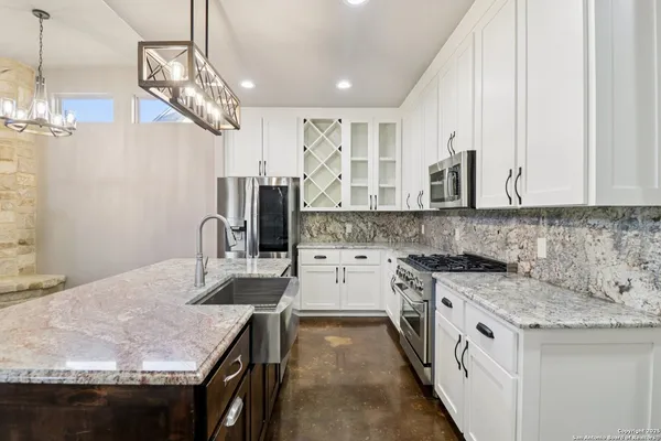 a kitchen with stainless steel appliances granite countertop a sink stove and refrigerator
