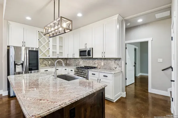 a kitchen with stainless steel appliances granite countertop a sink refrigerator and microwave