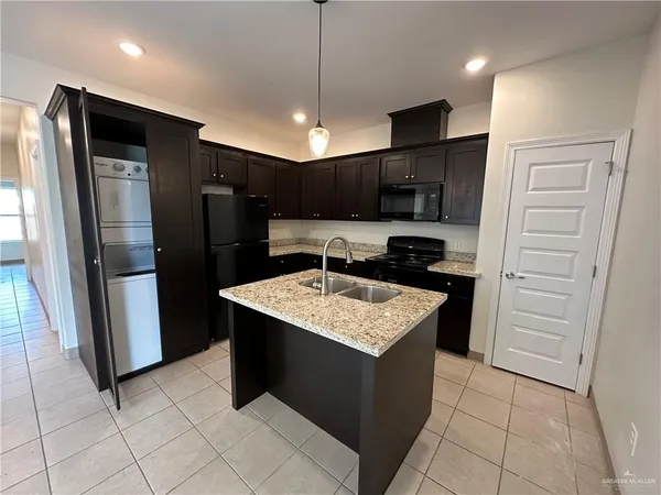 a kitchen with stainless steel appliances granite countertop a refrigerator a sink and a stove