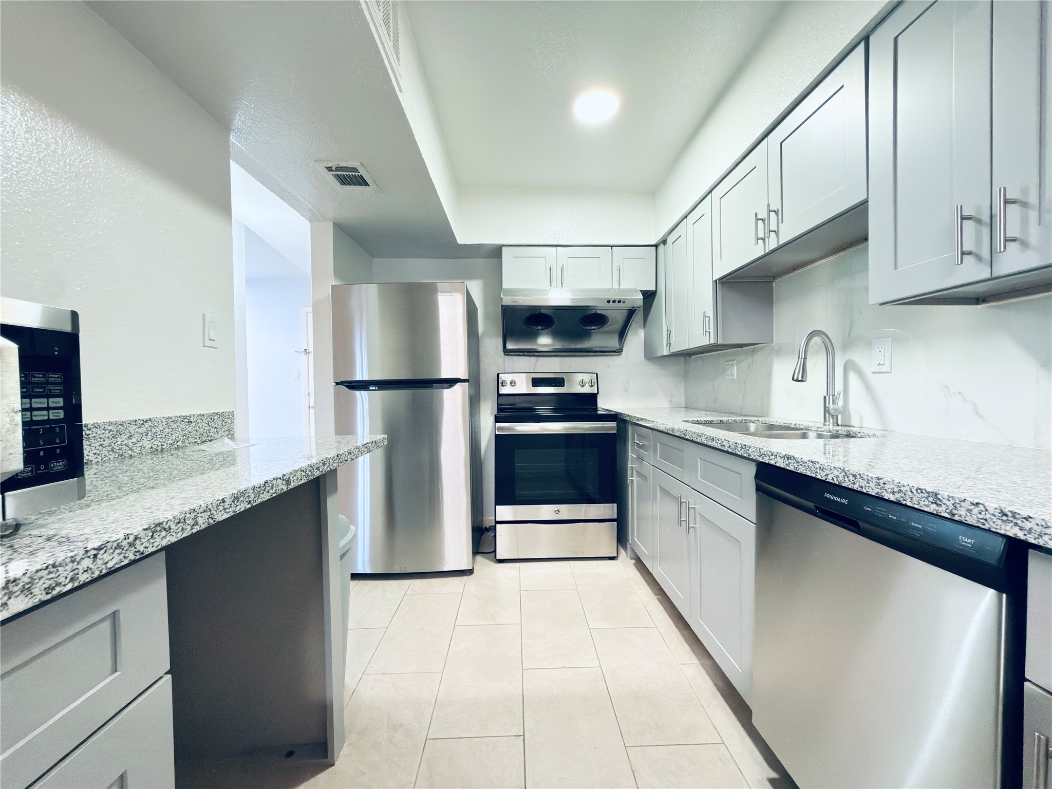 6201 Ranchester Drive, Unit 29 Houston, TX 77036 - Photo 1 of 23 Newly renovated sleek modern kitchen featuring stainless steel appliances, granite countertops, and ample cabinet space in a bright, open layout.