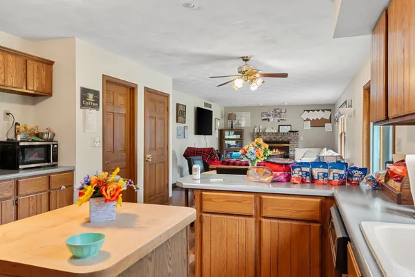 a view of a dining room with furniture a chandelier and kitchen view