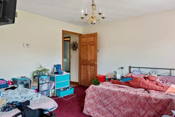 a bedroom with a bed and a chandelier