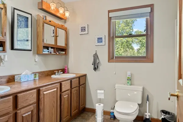 a bathroom with a granite countertop toilet sink and mirror