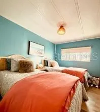 a bedroom with a bed and a large mirror