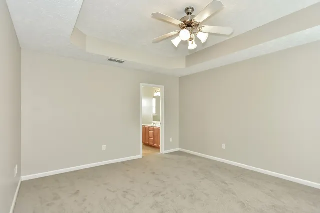 an empty room with a ceiling fan and a window