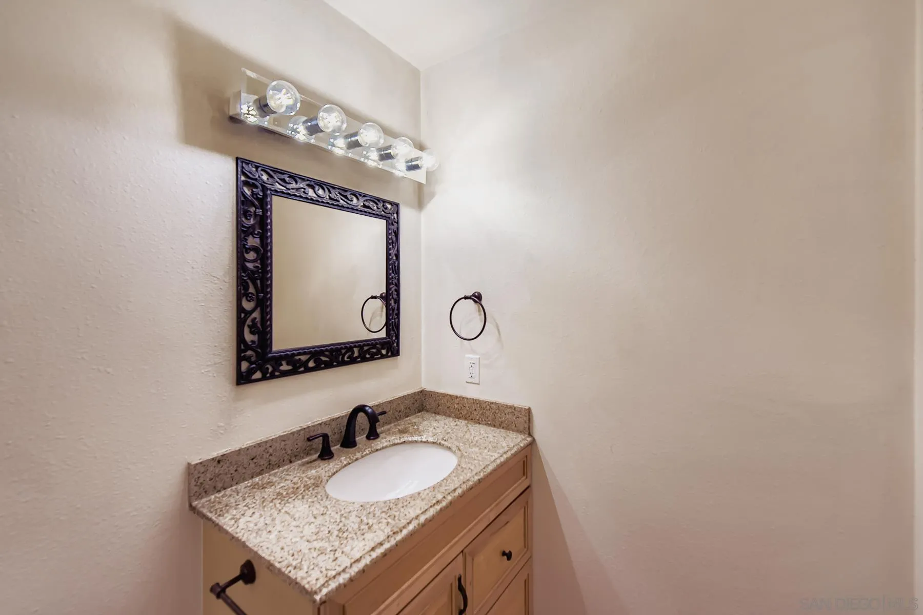 5977 Agee Street San Diego, CA 92122 - Photo 13 of 25 a bathroom with a granite countertop sink and a mirror