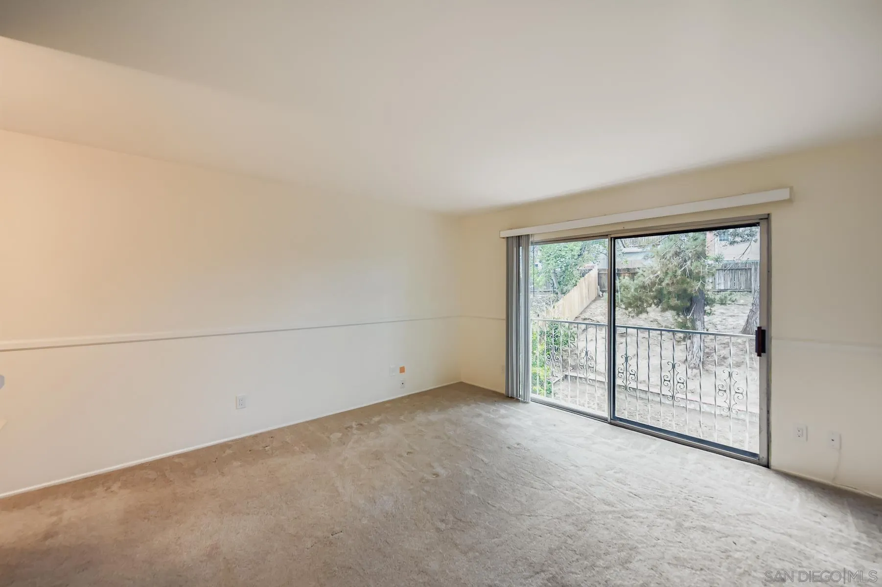 5977 Agee Street San Diego, CA 92122 - Photo 16 of 25 an empty room with sliding glass door and garden view