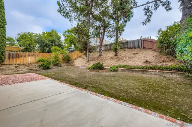 a view of a yard with wooden fence