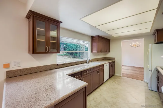 a large kitchen with stainless steel appliances granite countertop a sink and a stove
